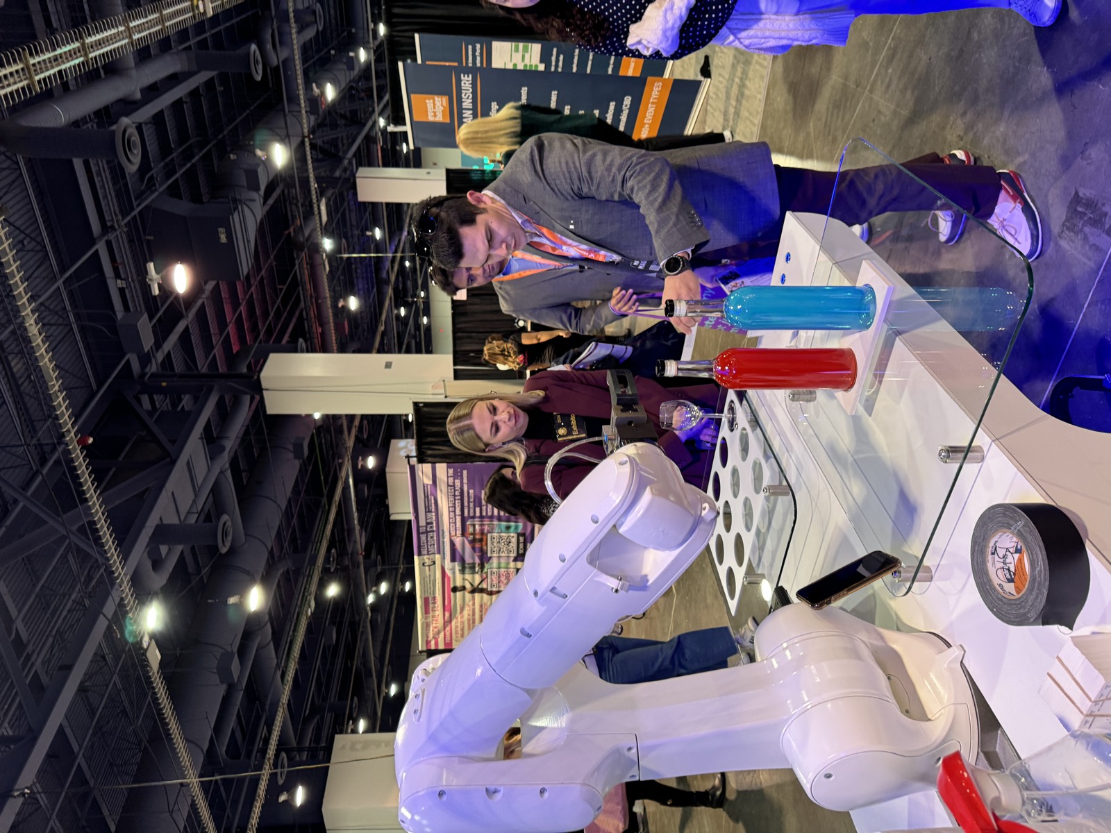 Guests watching the RoboBar robot bartender pour at a Las Vegas trade show booth