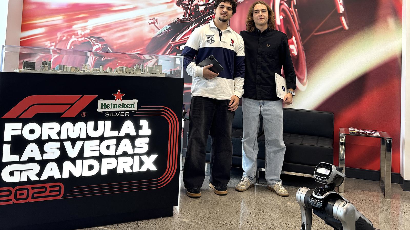 Guests posing with the RoboDog robot dog at the Formula 1 Las Vegas Grand Prix wall