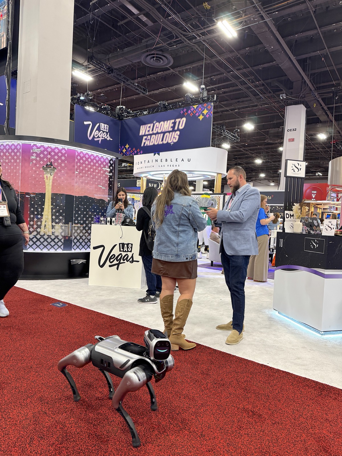 Attendees filming the RoboDog robot dog on the IMEX America show floor in Las Vegas